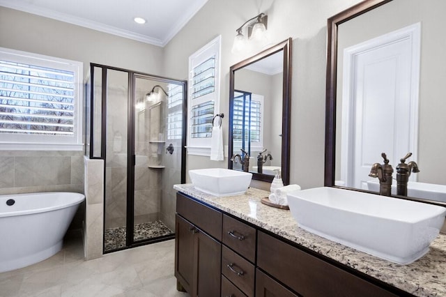 bathroom featuring plus walk in shower, vanity, crown molding, and a healthy amount of sunlight