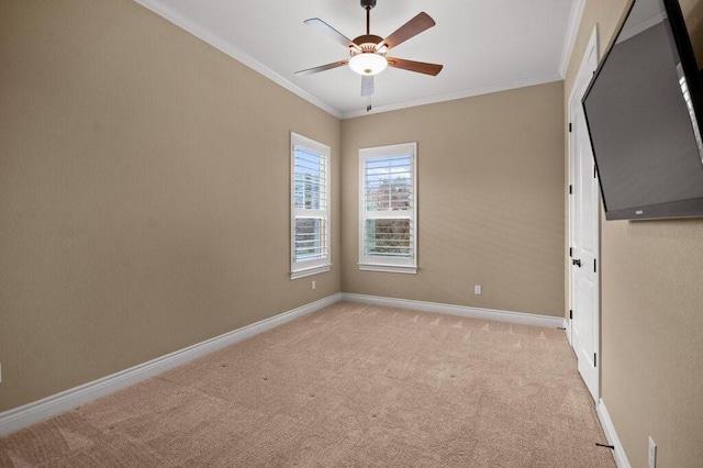 carpeted empty room featuring ceiling fan and crown molding