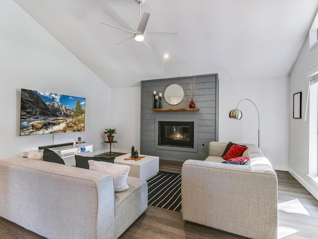 living room with dark hardwood / wood-style flooring, vaulted ceiling, a large fireplace, and ceiling fan