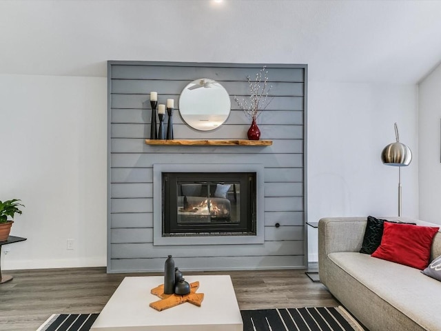 living room featuring dark wood-type flooring and a large fireplace