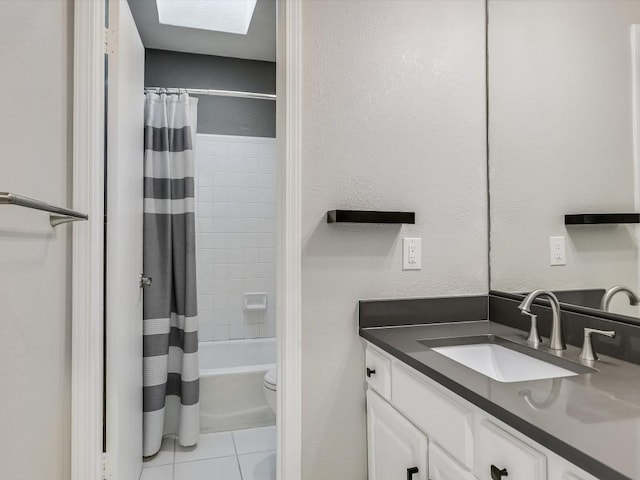 full bathroom featuring toilet, a skylight, vanity, shower / bath combo, and tile patterned flooring