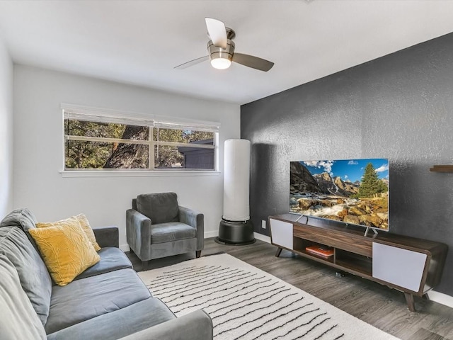 living room with dark wood-type flooring and ceiling fan