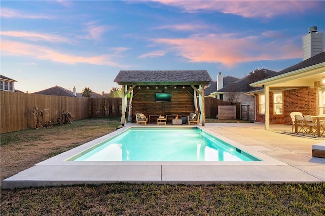 pool at dusk with a patio area