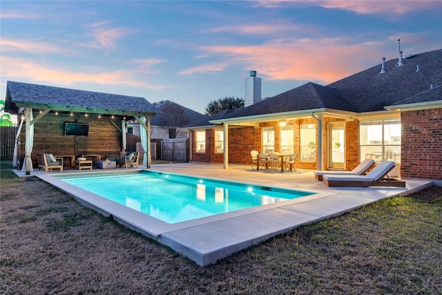 pool at dusk featuring a patio