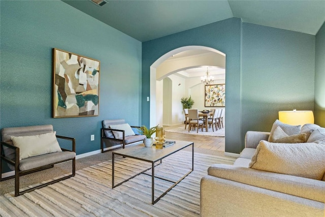 living area with lofted ceiling and an inviting chandelier