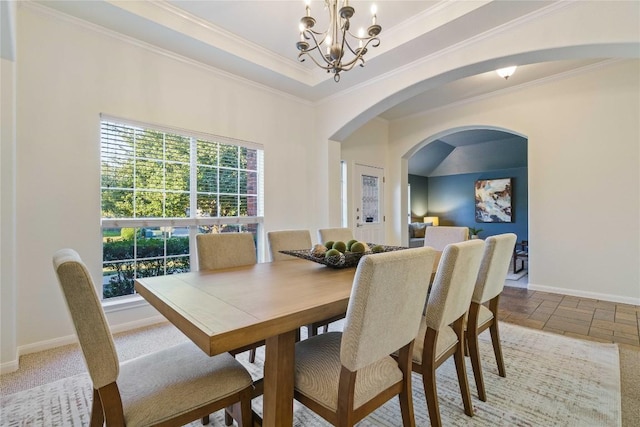 dining room featuring a raised ceiling, crown molding, and a chandelier