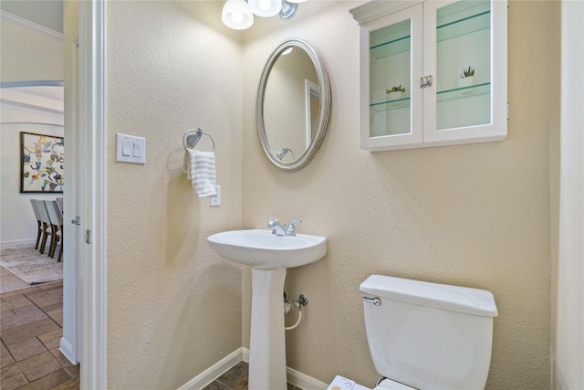 bathroom with crown molding, sink, and toilet