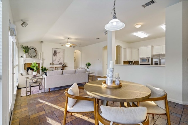 dining space with ceiling fan and vaulted ceiling