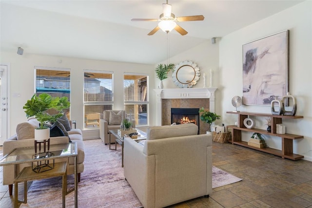 living room featuring ceiling fan and a tiled fireplace