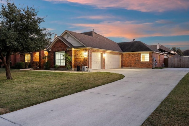 ranch-style house featuring a garage and a yard