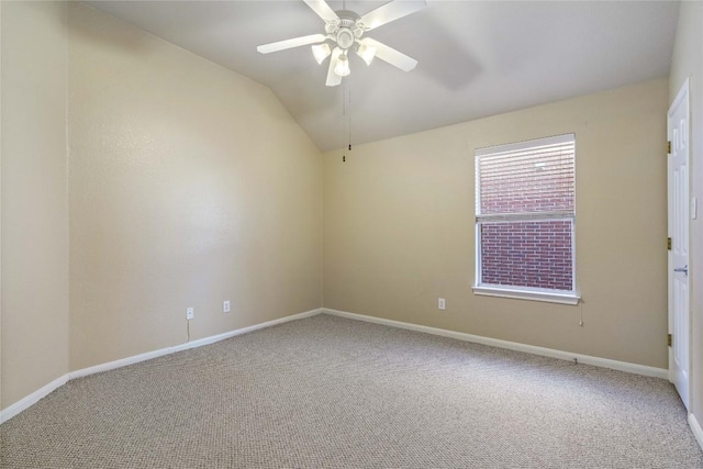 empty room featuring carpet floors, vaulted ceiling, and ceiling fan