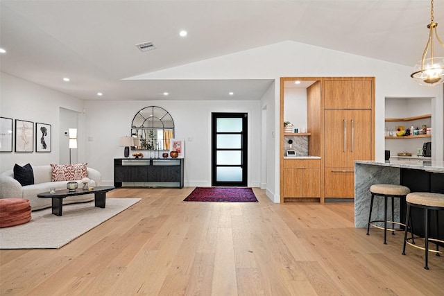 entryway featuring vaulted ceiling and light hardwood / wood-style flooring