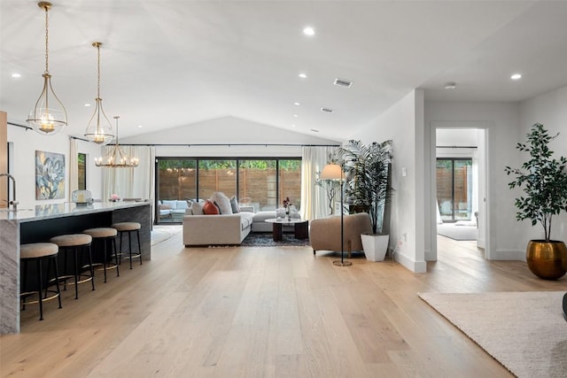 interior space with light hardwood / wood-style flooring, a chandelier, and vaulted ceiling