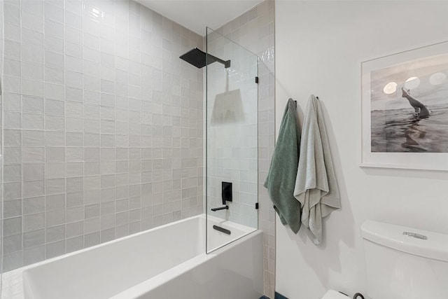 bathroom featuring tiled shower / bath combo and toilet