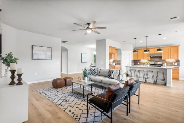 living room featuring ceiling fan and light hardwood / wood-style floors