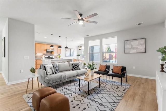 living room with light hardwood / wood-style floors and ceiling fan