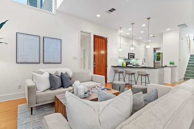 living room with light hardwood / wood-style flooring and sink