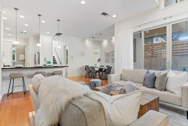 living room featuring light wood-type flooring and sink