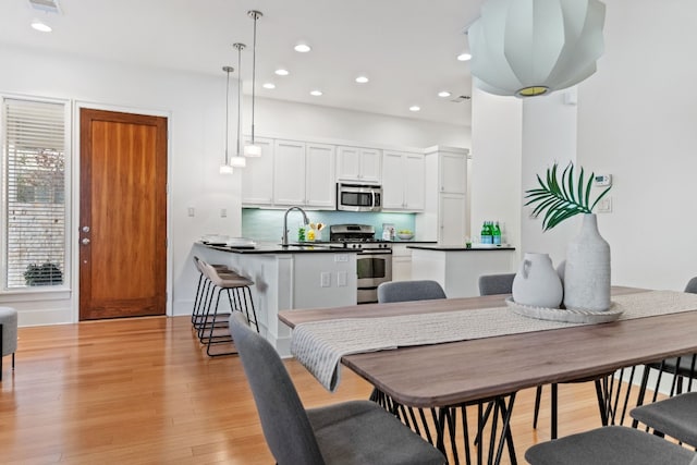 dining space with sink and light hardwood / wood-style floors