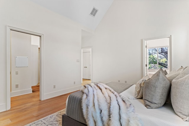 bedroom featuring light hardwood / wood-style floors and high vaulted ceiling