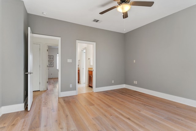 unfurnished bedroom featuring light hardwood / wood-style floors, ensuite bath, and ceiling fan