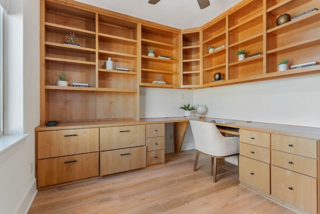 office with ceiling fan, built in desk, and light hardwood / wood-style flooring