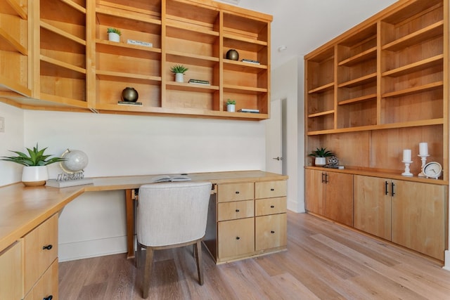 office space with light hardwood / wood-style flooring and built in desk