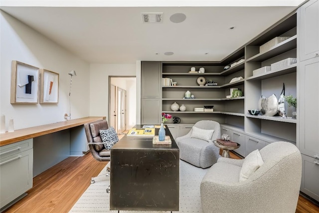 home office featuring built in desk and light wood-type flooring