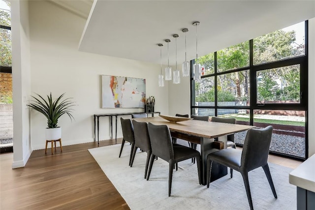 dining space with wood-type flooring and a wall of windows