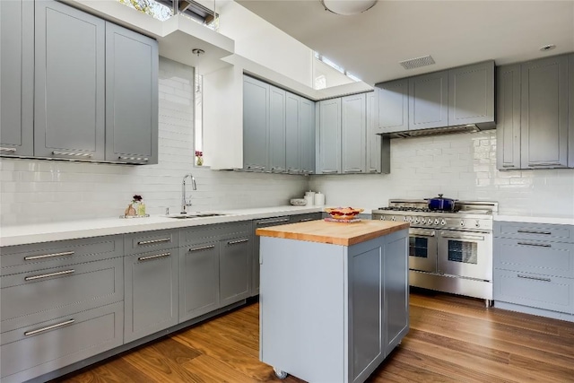 kitchen featuring wood counters, sink, range with two ovens, dark hardwood / wood-style floors, and a kitchen island