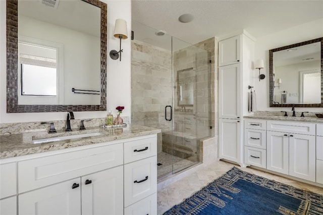 bathroom with vanity and a shower with door