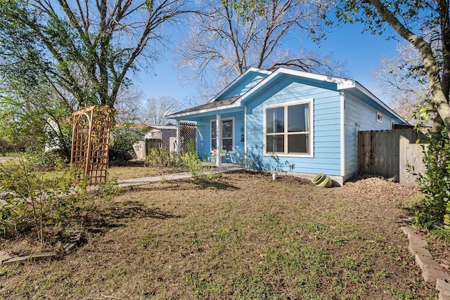 bungalow with a front yard and fence