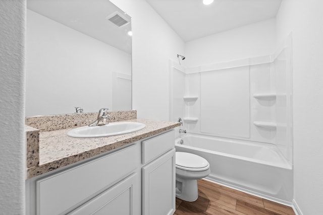 full bathroom featuring hardwood / wood-style floors, vanity,  shower combination, and toilet