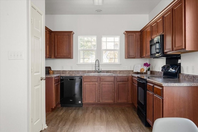 kitchen with dark wood-type flooring, sink, and black appliances