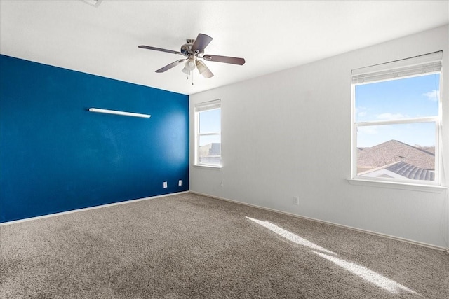 carpeted spare room featuring ceiling fan