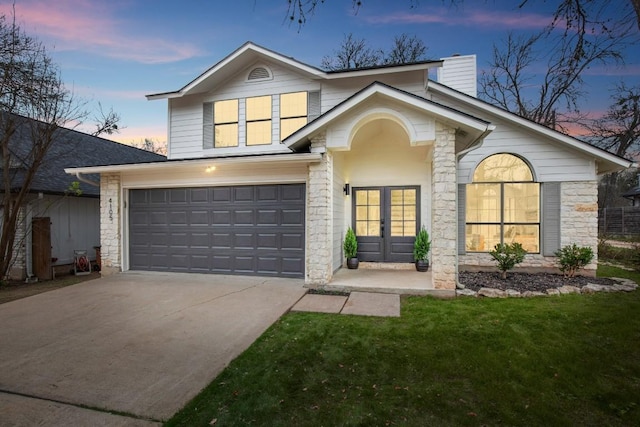 view of front of home featuring a garage and a lawn