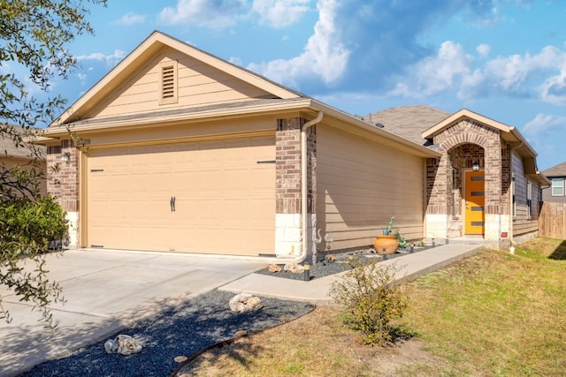 ranch-style house with an attached garage, a front lawn, concrete driveway, and brick siding