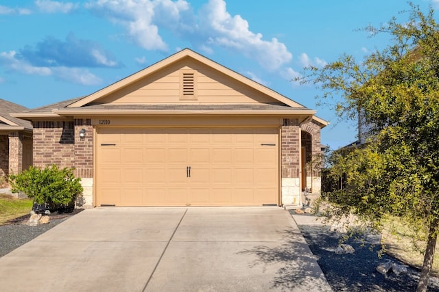 ranch-style home featuring a garage, concrete driveway, and brick siding