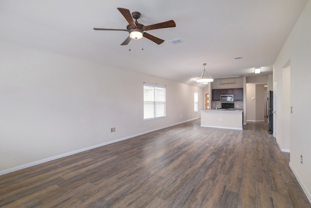 12110 Riprap Dr, Manor, TX 78653 - unfurnished living room featuring dark wood-type flooring, ceiling fan, and baseboards