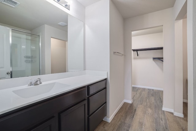 12110 Riprap Dr, Manor, TX 78653 - full bath with a shower stall, wood finished floors, a spacious closet, vanity, and baseboards