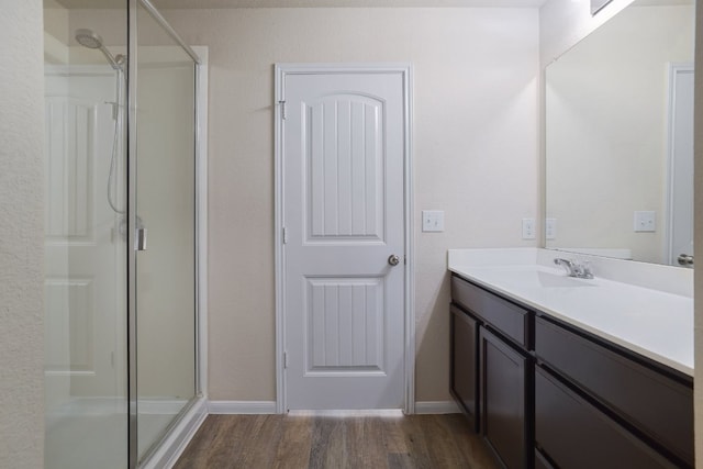 12110 Riprap Dr, Manor, TX 78653 - bathroom with a stall shower, vanity, wood finished floors, and baseboards