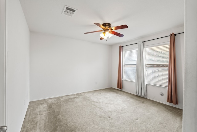 carpeted spare room featuring ceiling fan