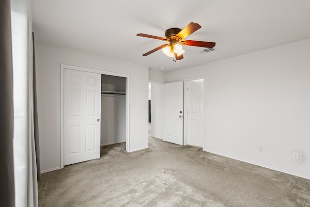 unfurnished bedroom featuring ceiling fan, a closet, and light colored carpet