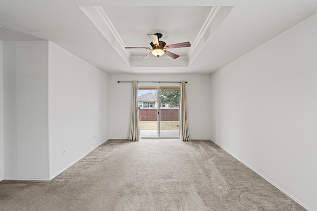 empty room featuring carpet flooring, ceiling fan, and a raised ceiling