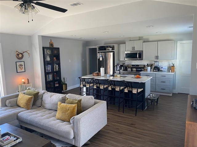 living room featuring lofted ceiling, ceiling fan, dark wood-type flooring, and sink