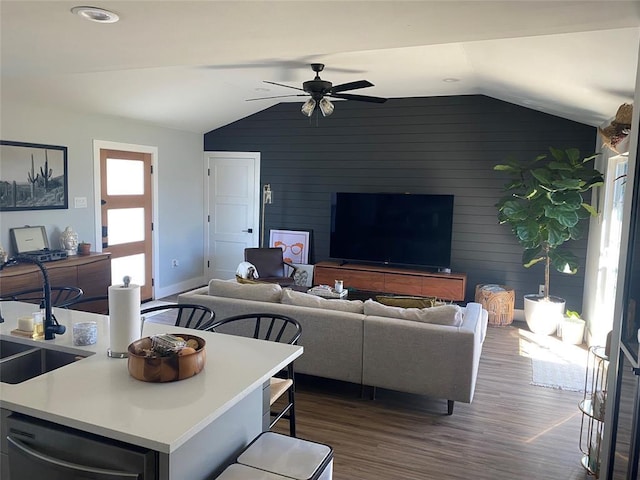 living room featuring dark hardwood / wood-style flooring, ceiling fan, lofted ceiling, and wood walls