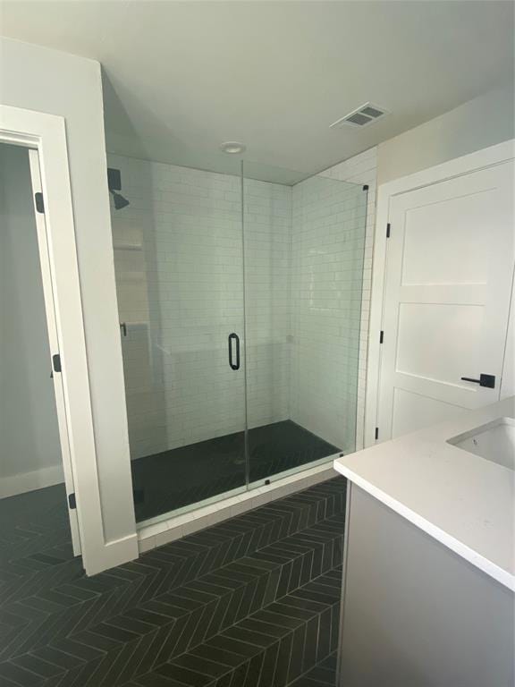 bathroom featuring vanity and a shower with door