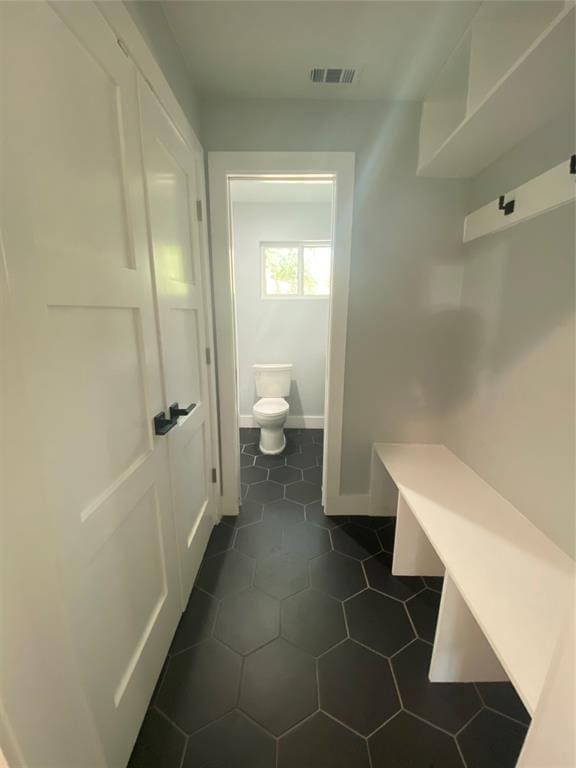 mudroom with dark tile patterned flooring