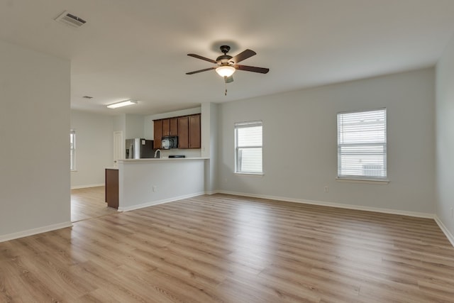 unfurnished living room featuring ceiling fan and light hardwood / wood-style floors