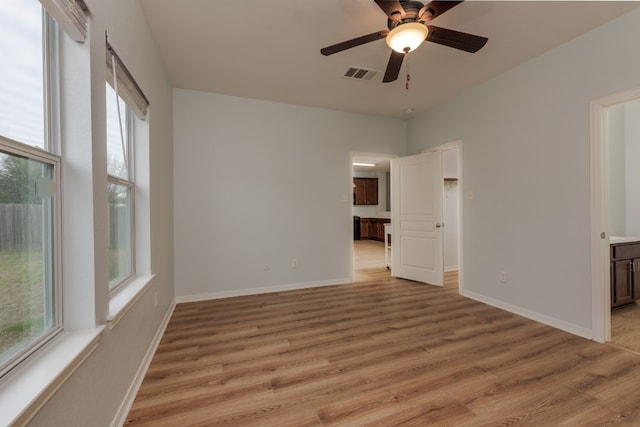 spare room featuring a wealth of natural light, ceiling fan, and light wood-type flooring